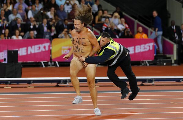 Um manifestante nu é abordado por um segurança depois de invadir a pista de corrida no mundial de atletismo em Londres. - Sputnik Brasil