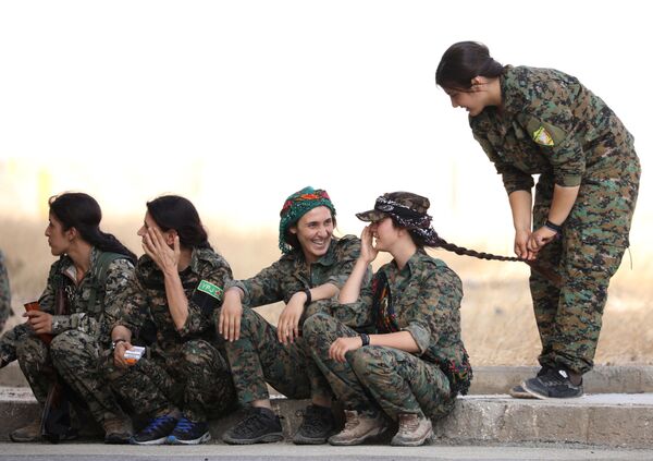 Mulheres combatentes das Forças Democráticas Sírias esperam na beira da estrada na cidade de Hasaka, no nordeste da Síria - Sputnik Brasil
