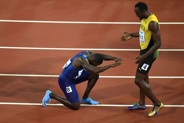 O atleta norte-americano Justin Gatlin se ajoelha perante a estrela jamaicana Usain Bolt após derrotá-lo na corrida de 100 metros no Mundial de Atletismo 2017, em Londres - Sputnik Brasil