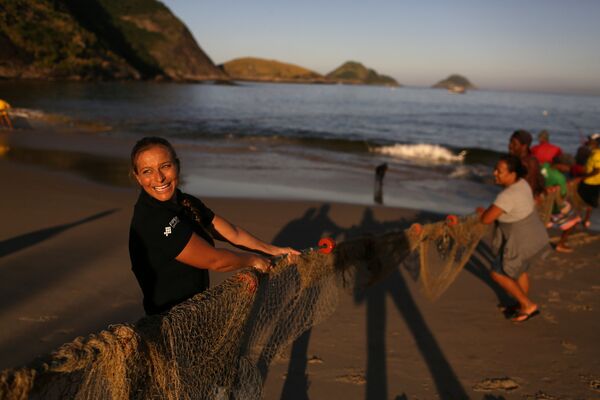 Sereia e instrutora de mergulho, Luciana Fuzetti ajuda pescadores a puxar uma rede em uma praia de Niterói, Brasil, em 13 de julho de 2017 - Sputnik Brasil