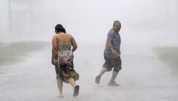 Texans run through the street during a band of heavy rain from Hurricane Harvey Saturday, Aug. 26, 2017, in Palacios, Texas. - Sputnik Brasil
