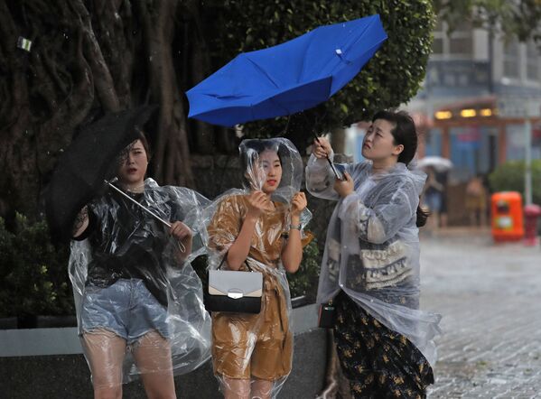 Meninas com guarda-chuvas em Hong-Kong - Sputnik Brasil