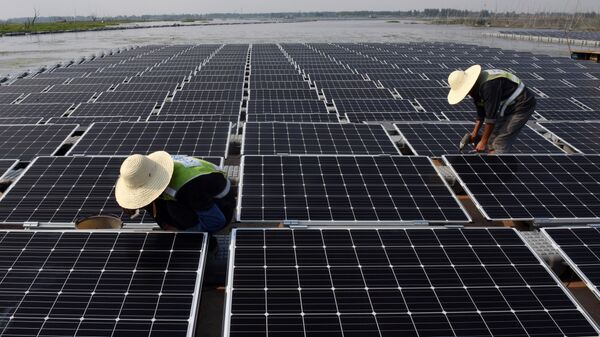 Funcionários trabalham em meio a placas fotovoltaicas. - Sputnik Brasil