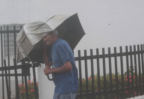 Homem com guarda-chuvas tenta resistir à força do furacão Irma, em Porto Rico - Sputnik Brasil