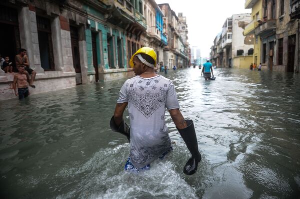 Cubanos andam pelas ruas inundadas de uma rua em Havana depois do furacão Irma ter atingido a capital - Sputnik Brasil
