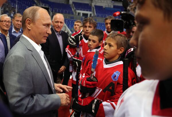 O presidente russo Vladimir Putin junto com jogadores de hóquei soviéticos e canadenses que tomaram parte da legendária supersérie de 1972 em Sochi se comunica com jovens atletas - Sputnik Brasil