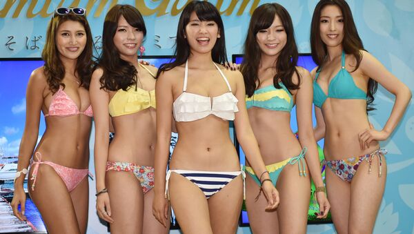 Japanese apparel maker San-ai's campaign girl Ikumi Hisamatsu (C) and models display the company's latest swimsuits during a collection supported by the Guam Visitors Bureau as part of the Tourism EXPO Japan, in Tokyo. (File) - Sputnik Brasil