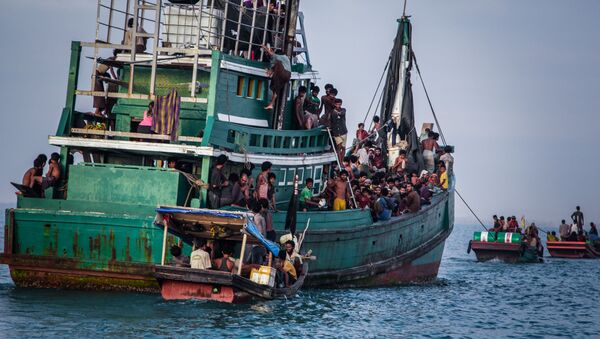 In this photo taken on May 20, 2015 shows Rohingya migrants resting on a boat off the coast near Kuala Simpang Tiga in Indonesia's East Aceh district of Aceh province before being rescued. Indonesia's foreign minister demanded answers from Canberra about claims Australian officials paid thousands of dollars to turn a boat back to Indonesia after Prime Minister Tony Abbott refused to deny the allegations - Sputnik Brasil