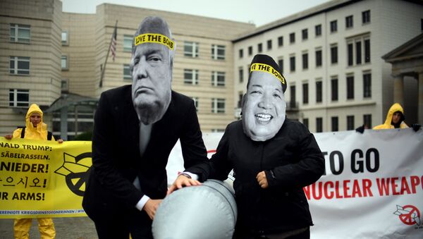 Ativistas a favor da abolição das armas nucleares com máscaras de Donal Trump e Kim Jong-un em frente à embaixada da Coreia do Norte em Berlim, 13 de setembro de 2017 - Sputnik Brasil