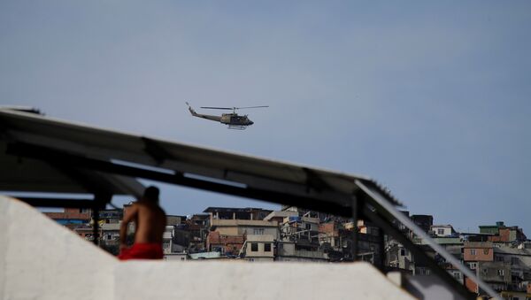 A military helicopter flies overhead during an operation after violent clashes between drug gangs in Rocinha slum in Rio de Janeiro, Brazil - Sputnik Brasil
