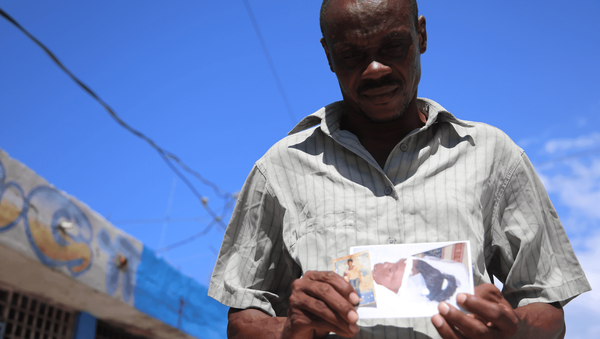 O vendedor Ilphim Jean Gilles (51 anos) mostra a foto da filha Woodeline, morta em 2013 aos 24 anos vítima de cólera: Ela era minha primogênita, tudo pra mim. Os soldados da ONU levaram embora minha esperança. - Sputnik Brasil
