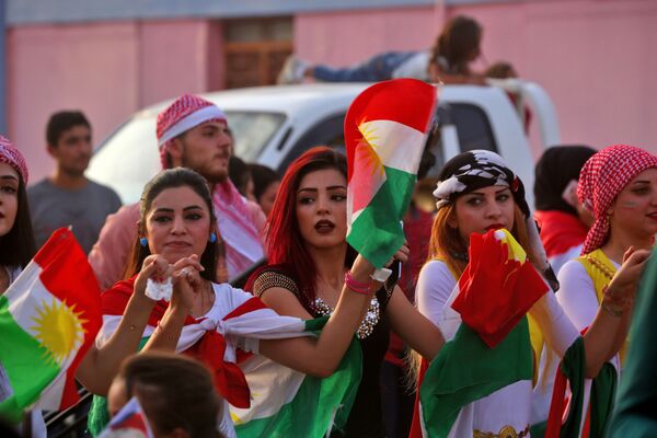 Curdas sírias dançando com a bandeira curda durante celebrações a favor do referendo no Curdistão iraquiano - Sputnik Brasil