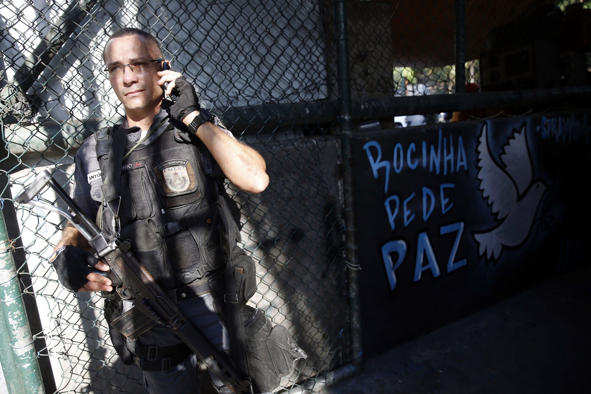 Policial militar ao lado de mensagem de paz na comunidade da Rocinha, no Rio de Janeiro (RJ) - Sputnik Brasil, 1920, 13.01.2023