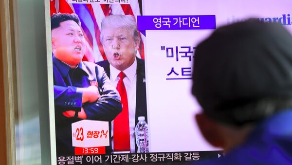 Um homem a ver programa de notícias que mostra Donald Trump e Kim Jong-Un na estação ferroviária em Seul em 9 de agosto de 2017 - Sputnik Brasil