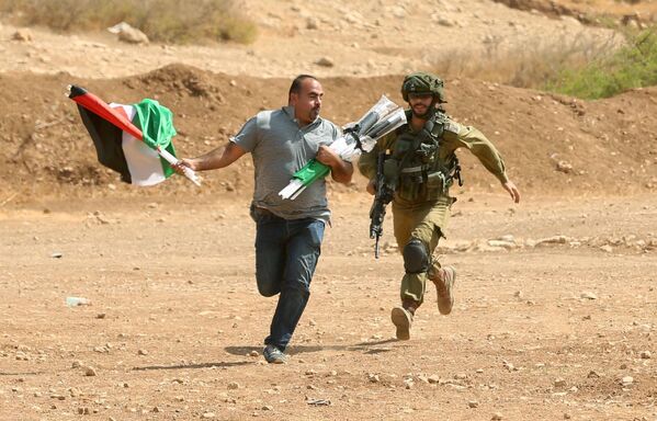Soldado israelense persegue palestino durante confrontos na Cisjordânia - Sputnik Brasil