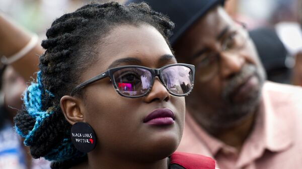 A young woman wears earrings with the slogan Black Lives Matter printed on them during the dedication and opening ceremony of the Smithsonian's National Museum of African American History and Culture in Washington, Saturday, Sept. 24, 2016. - Sputnik Brasil