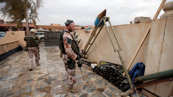 Soldado norte-americano olhando para as armas e as munições do Daesh em Mossul, Iraque - Sputnik Brasil