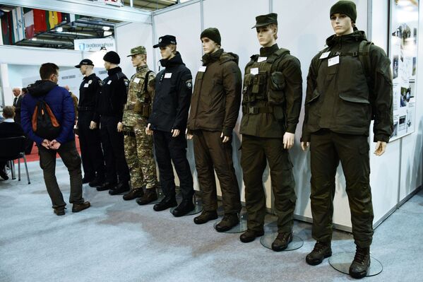Homem examina diferentes versões de uniformes militares expostas na mostra Armas e Segurança 2017 em Kiev - Sputnik Brasil