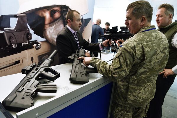 Homem examina armas de fogo na exposição Armas e Segurança 2017 em Kiev - Sputnik Brasil