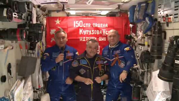 Bandeira da vitória com os cosmonautas russos na ISS. - Sputnik Brasil