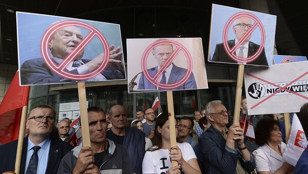 Manifestantes, fora do escritório do líder Jaroslaw Kaczynski, segurando bandeiras com imagens do empresário George Soros, do presidente do Conselho Europeu Donald Tusk e do primeiro vice-presidente da Comissão Européia, Frans Timmermans, durante um protesto em Varsóvia, em 26 de julho de 2017 - Sputnik Brasil