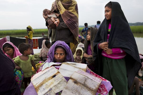 Mulher rohingya, em fuga de Mianmar para o Bangladesh, seca seus documentos na fronteira entre os dois países - Sputnik Brasil