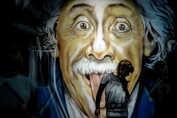 Menina passa em frente de grafite com imagem do físico de origem alemã Albert Einstein, na cidade bielorrussa de Minsk - Sputnik Brasil