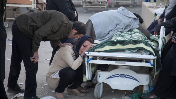 Mulher chorando junto a corpo de familiar após terremoto na província de Kermanshah, Irã - Sputnik Brasil