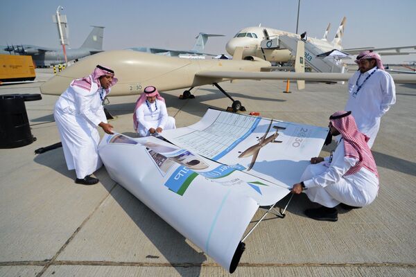 Participantes organizando cartaz sobre uma das aeronaves expostas no Salão Aeroespacial Dubai Airshow 2017, nos Emirados Árabes Unidos - Sputnik Brasil