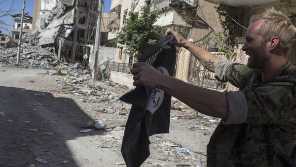 Soldado segurando bandeira do Daesh em Raqqa, Síria - Sputnik Brasil