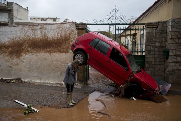 Mulher perto de carro levado por inundação em Atenas, Grécia - Sputnik Brasil