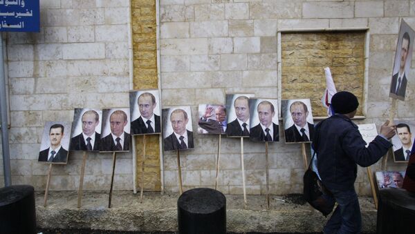 Photos of Syrian President Bashar Assad and Russian President Vladimir Putin are propped against a wall during a pro-Syrian government protest in front of the Russian Embassy in Damascus, Syria. (File) - Sputnik Brasil