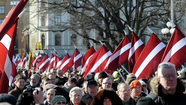 People carry Latvian flags at the march in Riga, Latvia - Sputnik Brasil
