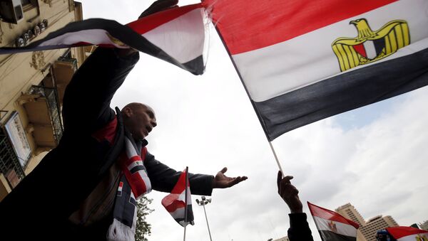 Pro-government protesters chant slogans while holding the national flag during the fifth anniversary of the uprising that ended 30-year reign of Hosni Mubarak in Cairo, Egypt, January 25, 2016 - Sputnik Brasil