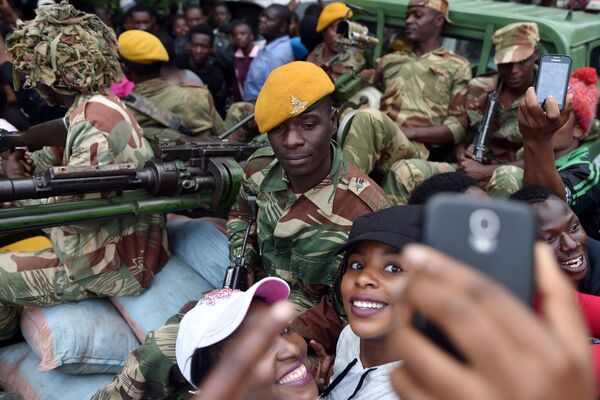 Meninas tiram foto com soldados do exército do Zimbábue durante marcha pela renúncia do presidente - Sputnik Brasil