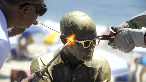 A estátua do poeta Carlos Drummond de Andrade, em Copacabana, no Rio de Janeiro, recebendo novos óculos, depois ter o objeto roubado pela nona vez, em janeiro de 2016 - Sputnik Brasil