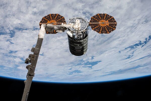 Nave espacial estadunidense Cygnus está sendo acoplado à Estação Espacial Internacional através de um braço robótico pelos astronautas Paolo Nespoli e Randy Bresnik, em 14 de novembro de 2017 - Sputnik Brasil